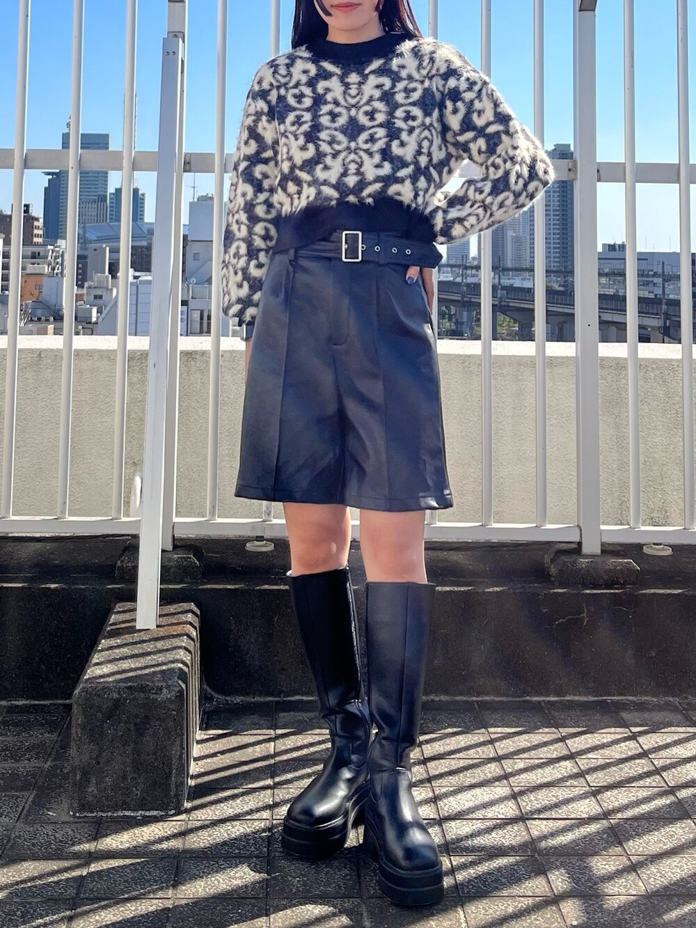 ブラック系のニット/セーター、ブラック系のその他パンツ、ブラック系のブーツを着用したレディースの秋コーディネートの5枚目の写真