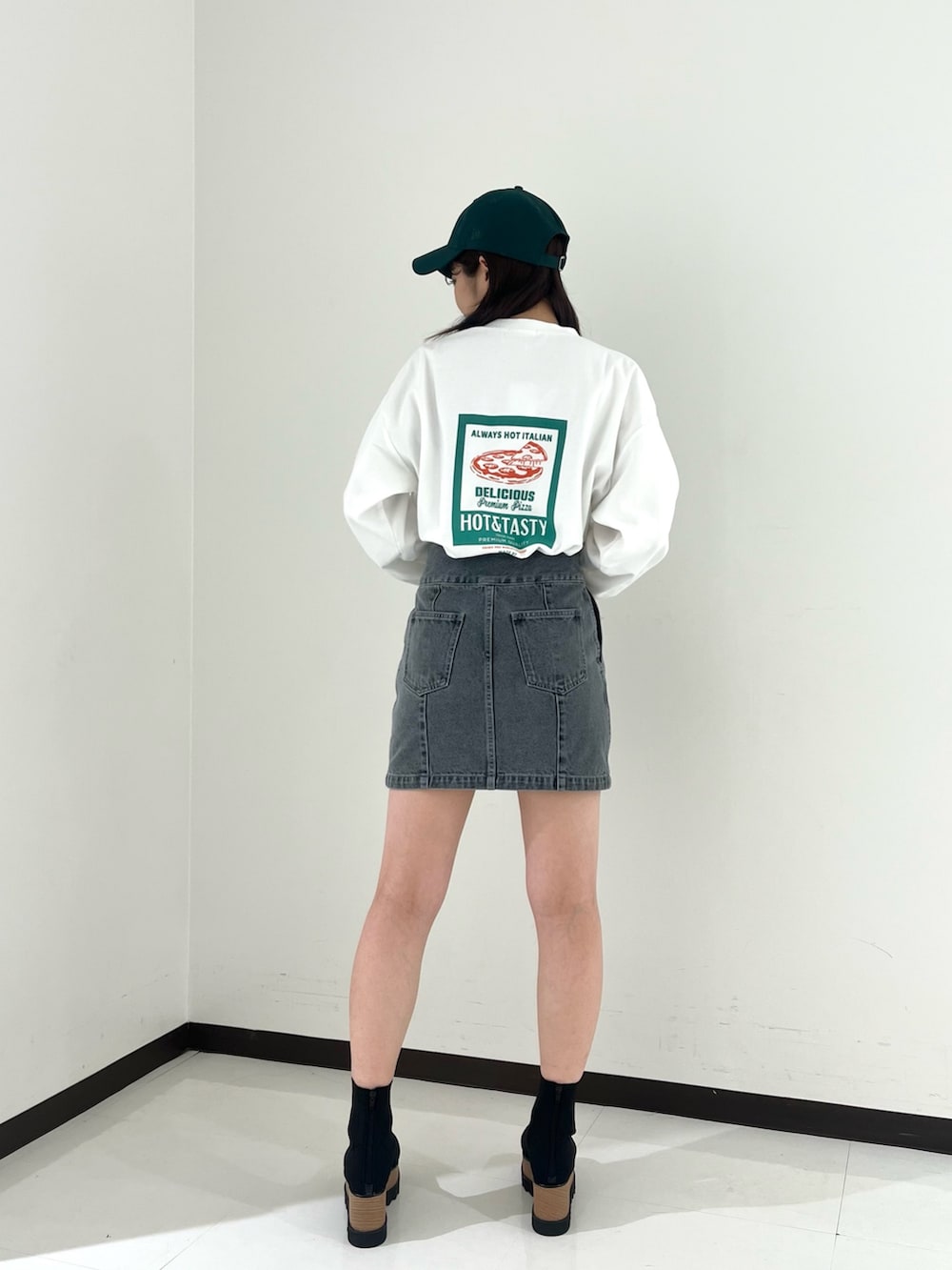 ホワイト系のTシャツ/カットソー、グレー系のスカート、ブラック系のブーツを着用したレディースの冬コーディネートの3枚目の写真