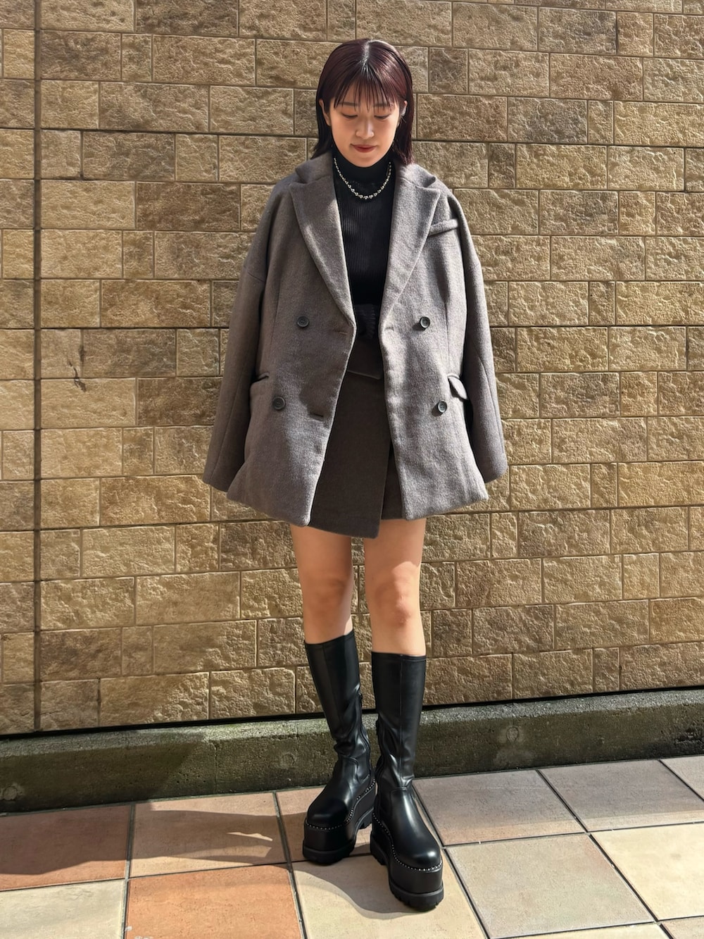 ブラック系のニット/セーター、ブラウン系のテーラードジャケット、ブラウン系のスカートを着用したレディースの秋コーディネートの2枚目の写真