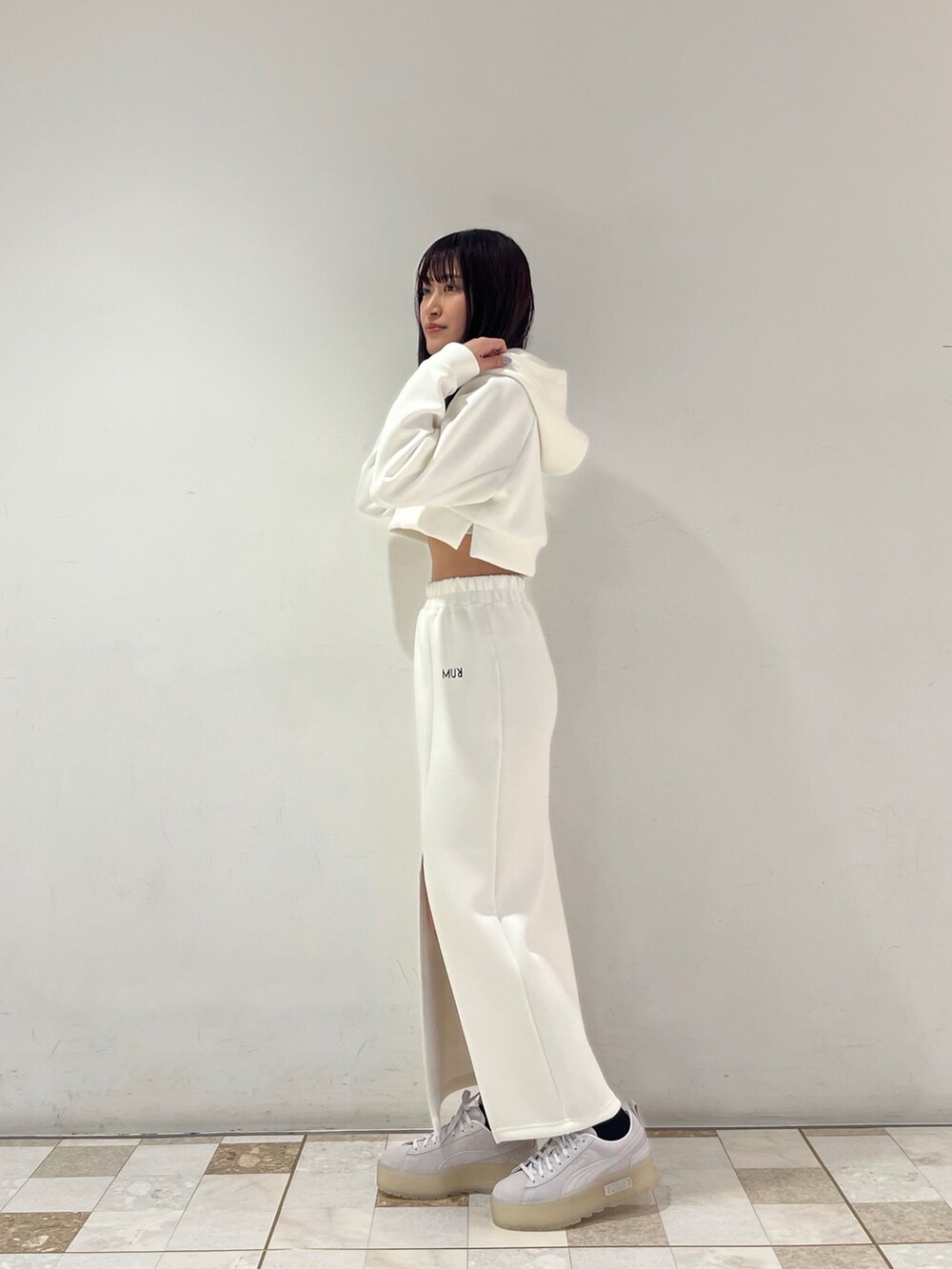 ホワイト系のTシャツ/カットソー、ホワイト系のスカート、グレー系のスニーカーを着用したレディースの春コーディネートの2枚目の写真