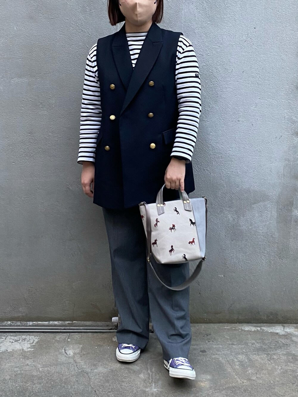 グレー系のショルダーバッグ、ブルー系のベスト、ホワイト系のTシャツ/カットソーを着用したレディースの春コーディネートの3枚目の写真