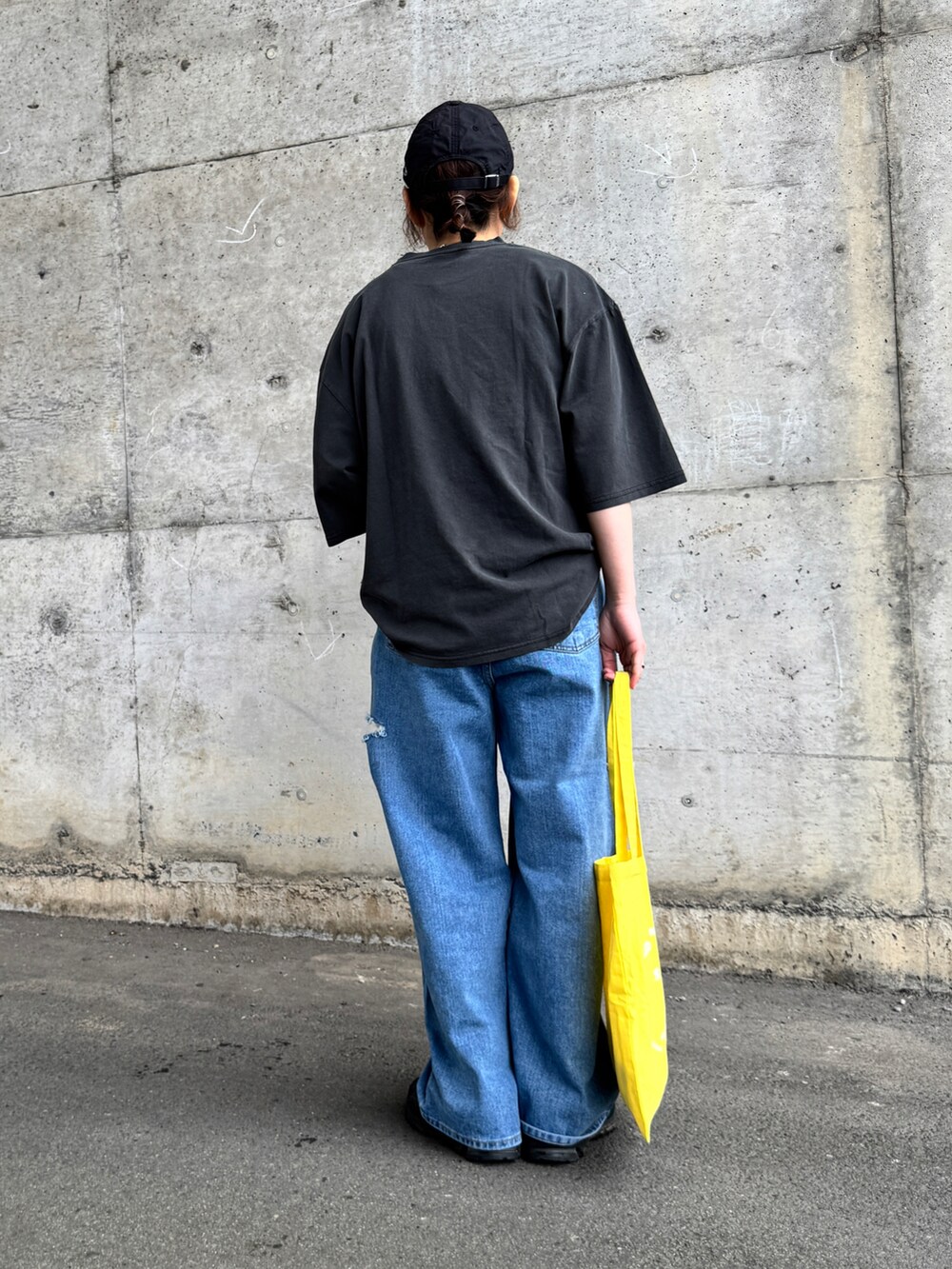 グレー系のTシャツ/カットソー、イエロー系のトートバッグ、ブラック系のキャップを着用したレディースの春コーディネートの3枚目の写真
