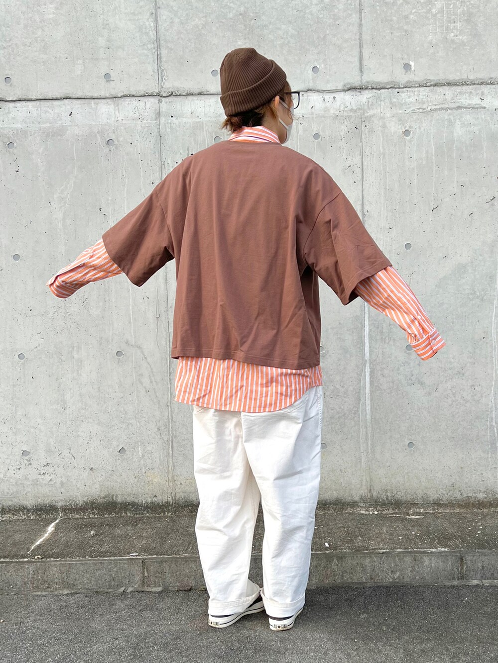 オレンジ系のシャツ/ブラウス、ベージュ系のその他パンツ、ブラウン系のスニーカーを着用したレディースの秋コーディネートの2枚目の写真