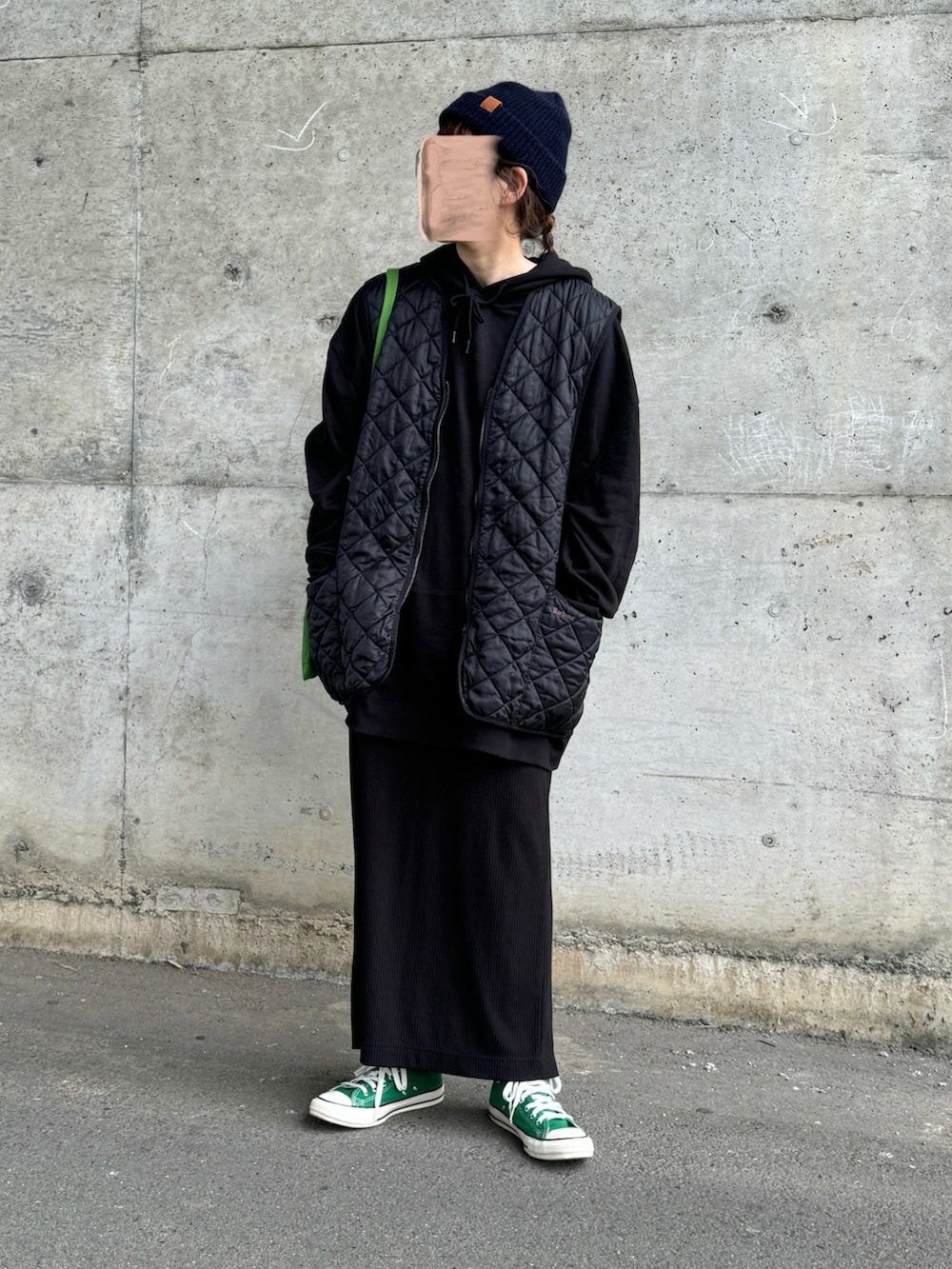 ブラック系のベスト、グリーン系のスニーカー、グリーン系のトートバッグを着用したレディースの冬コーディネートの3枚目の写真