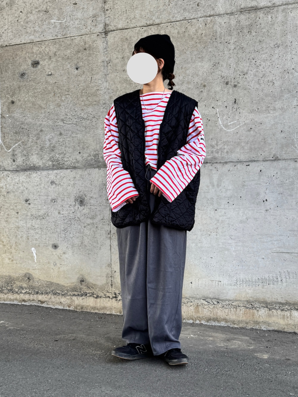 レッド系のTシャツ/カットソー、ブラック系のベスト、ブラック系のニットキャップ/ビーニーを着用したレディースの春コーディネートの2枚目の写真