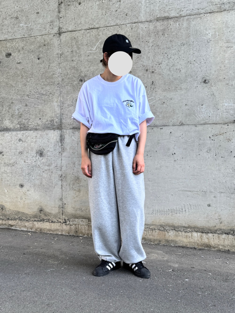 ホワイト系のTシャツ/カットソー、ブラック系のスニーカーを着用したレディースの夏コーディネートの2枚目の写真