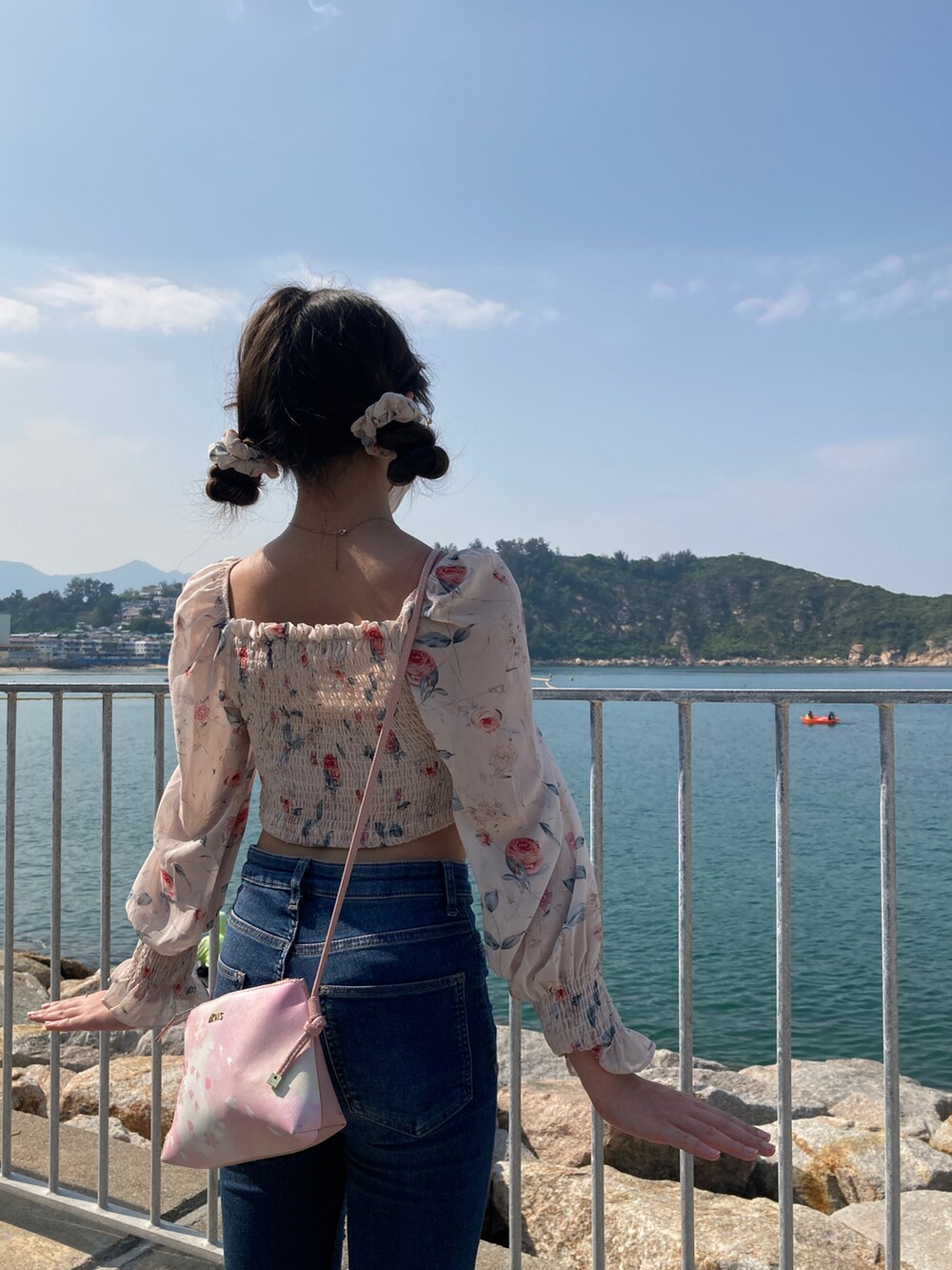 ホワイト系のスニーカー、ピンク系のバッグを着用したレディースの春コーディネートの3枚目の写真