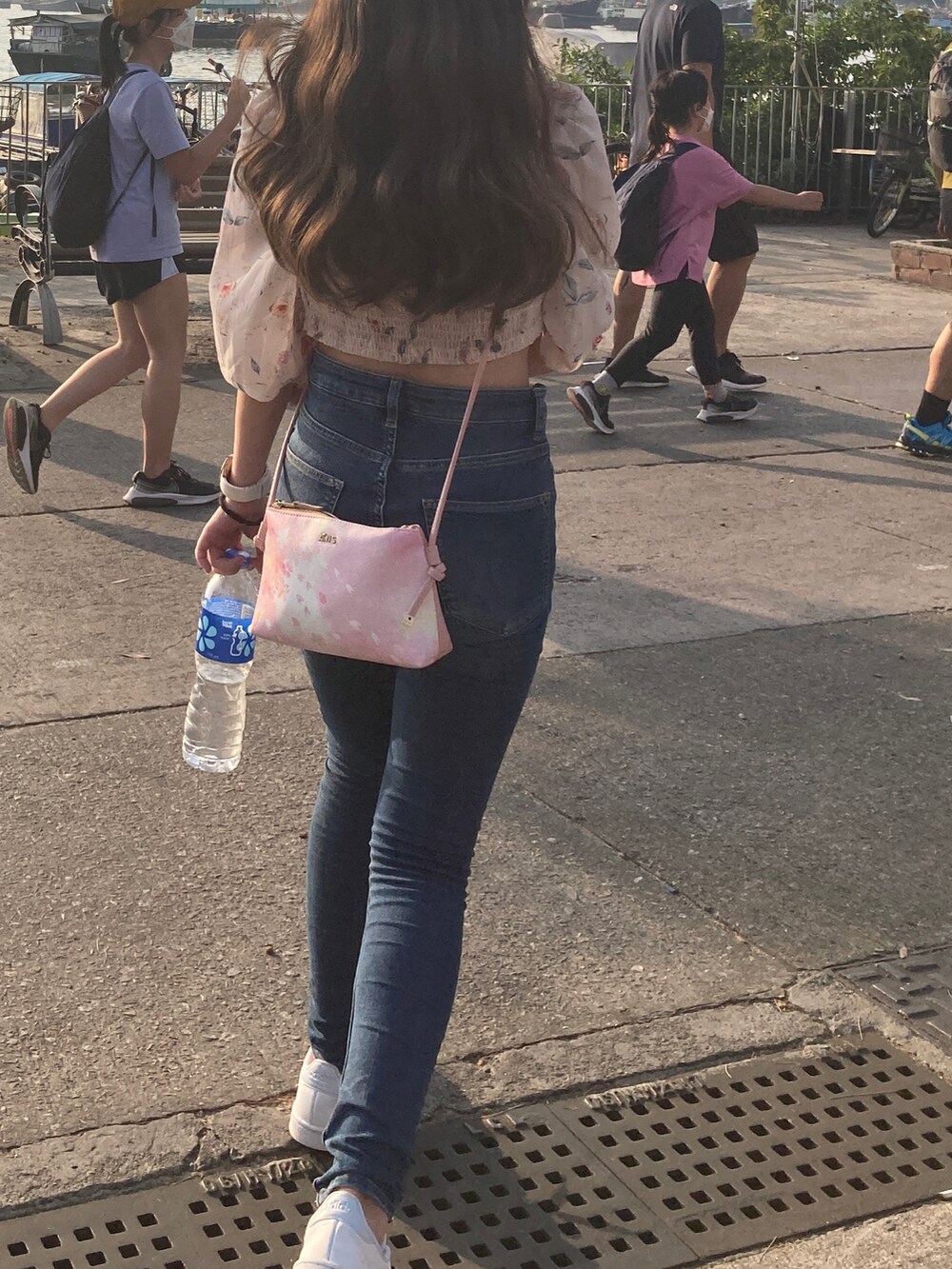 ホワイト系のスニーカー、ピンク系のバッグを着用したレディースの春コーディネートの2枚目の写真