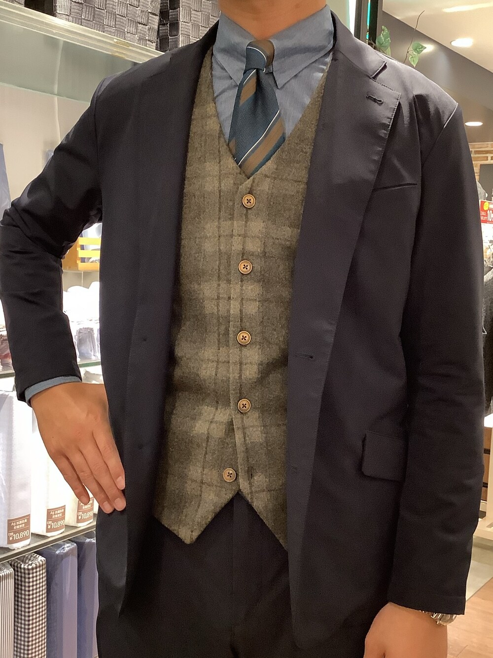 ブラウン系のベスト、その他のネクタイを着用したメンズの秋コーディネートの2枚目の写真