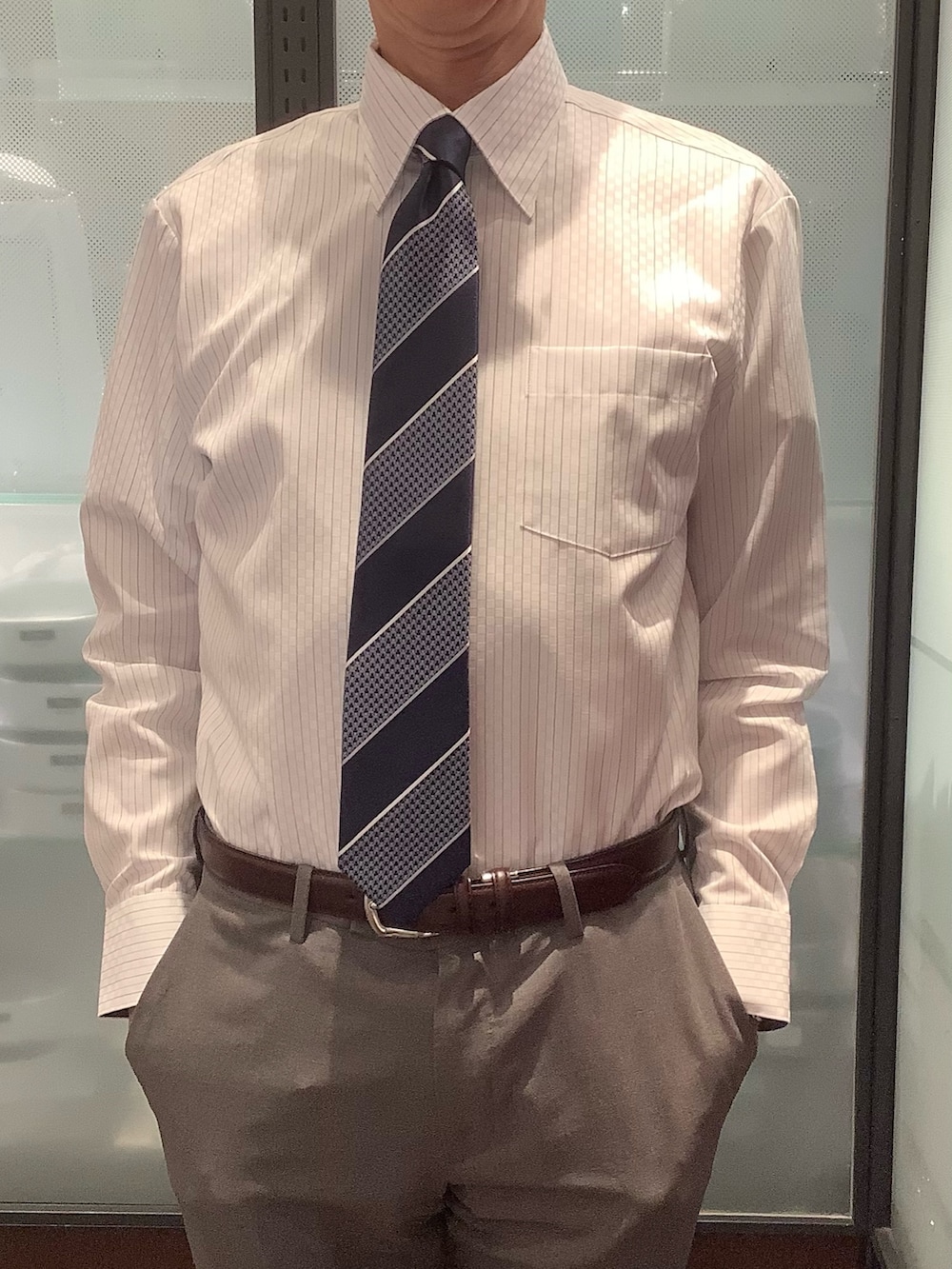 ブルー系のビジネスシャツを着用したメンズの冬コーディネートの2枚目の写真