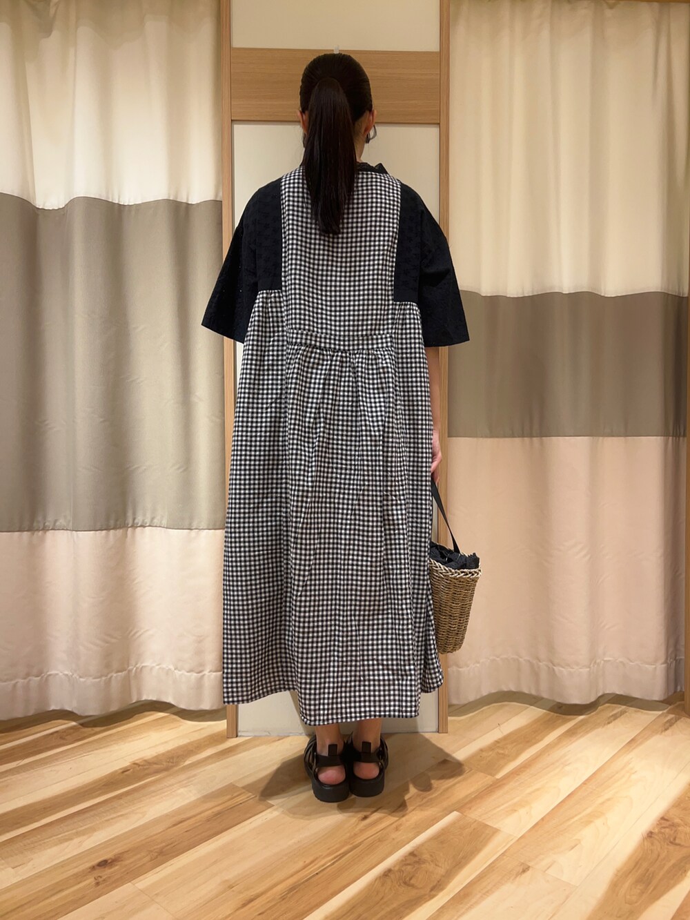 ブラック系のワンピース、ブラック系のハンドバッグ、ブラック系のサンダルを着用したレディースの春コーディネートの3枚目の写真