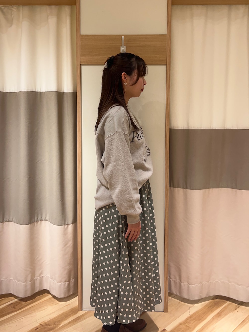 イエロー系のローファー、グリーン系のスカート、グレー系のトップスを着用したレディースの冬コーディネートの2枚目の写真