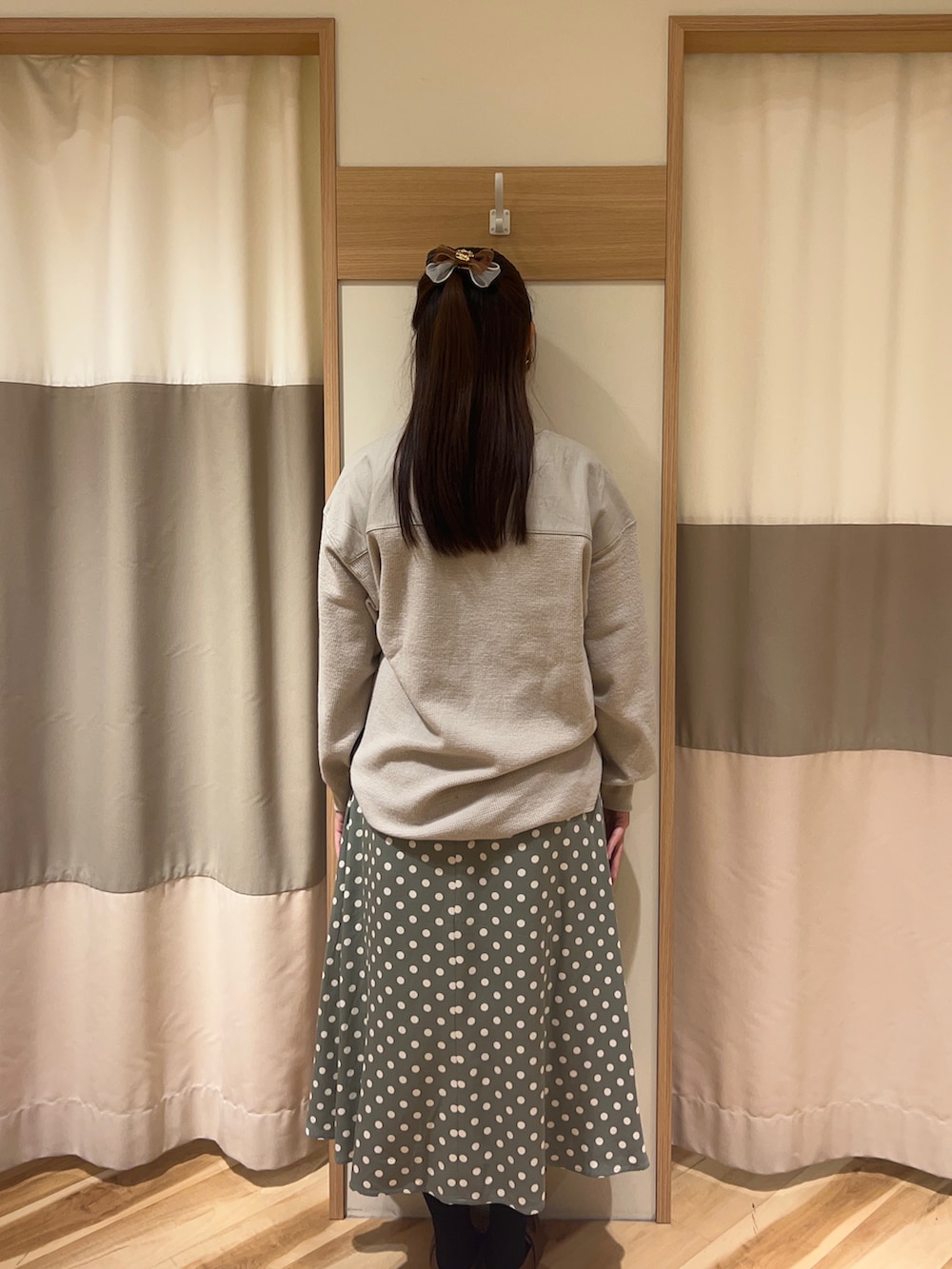 イエロー系のローファー、グリーン系のスカート、グレー系のトップスを着用したレディースの冬コーディネートの3枚目の写真