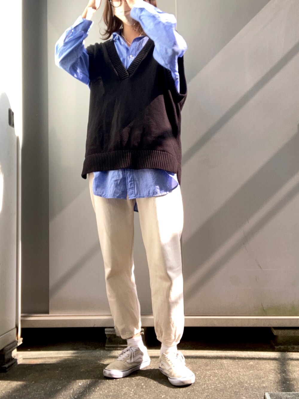 ブラック系のニット/セーター、ブルー系のシャツ/ブラウス、ベージュ系のスニーカーを着用したレディースの冬コーディネートの2枚目の写真