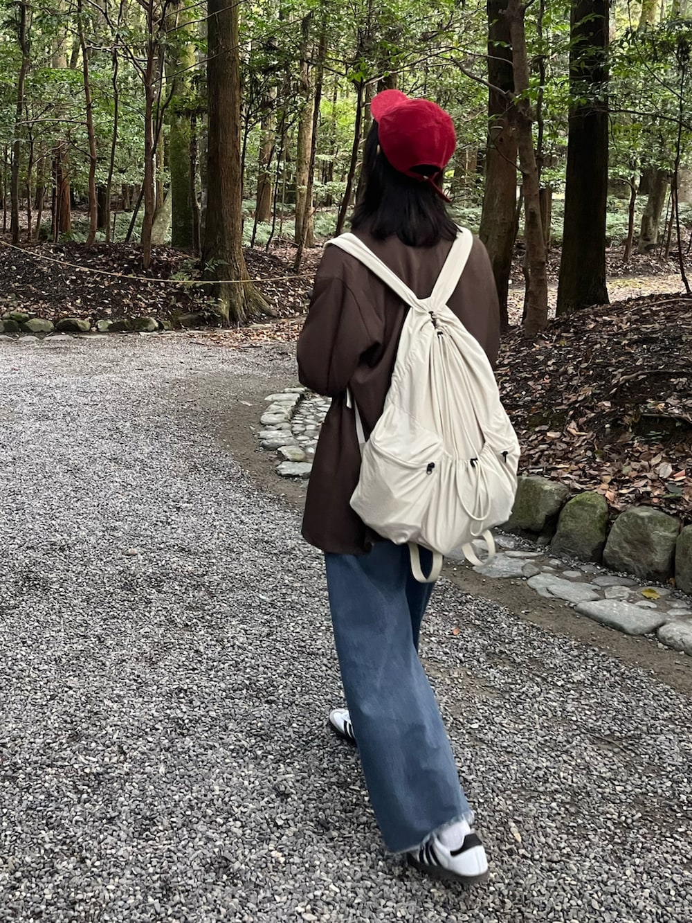 ブラウン系のテーラードジャケット、ホワイト系のスカート、ブルー系のデニムパンツを着用したレディースの秋コーディネートの2枚目の写真