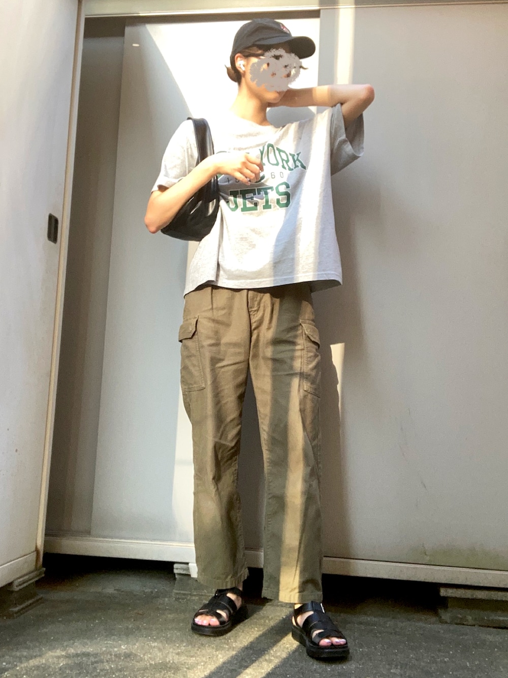 グレー系のTシャツ/カットソー、ブラック系のキャップを着用したレディースの秋コーディネートの2枚目の写真