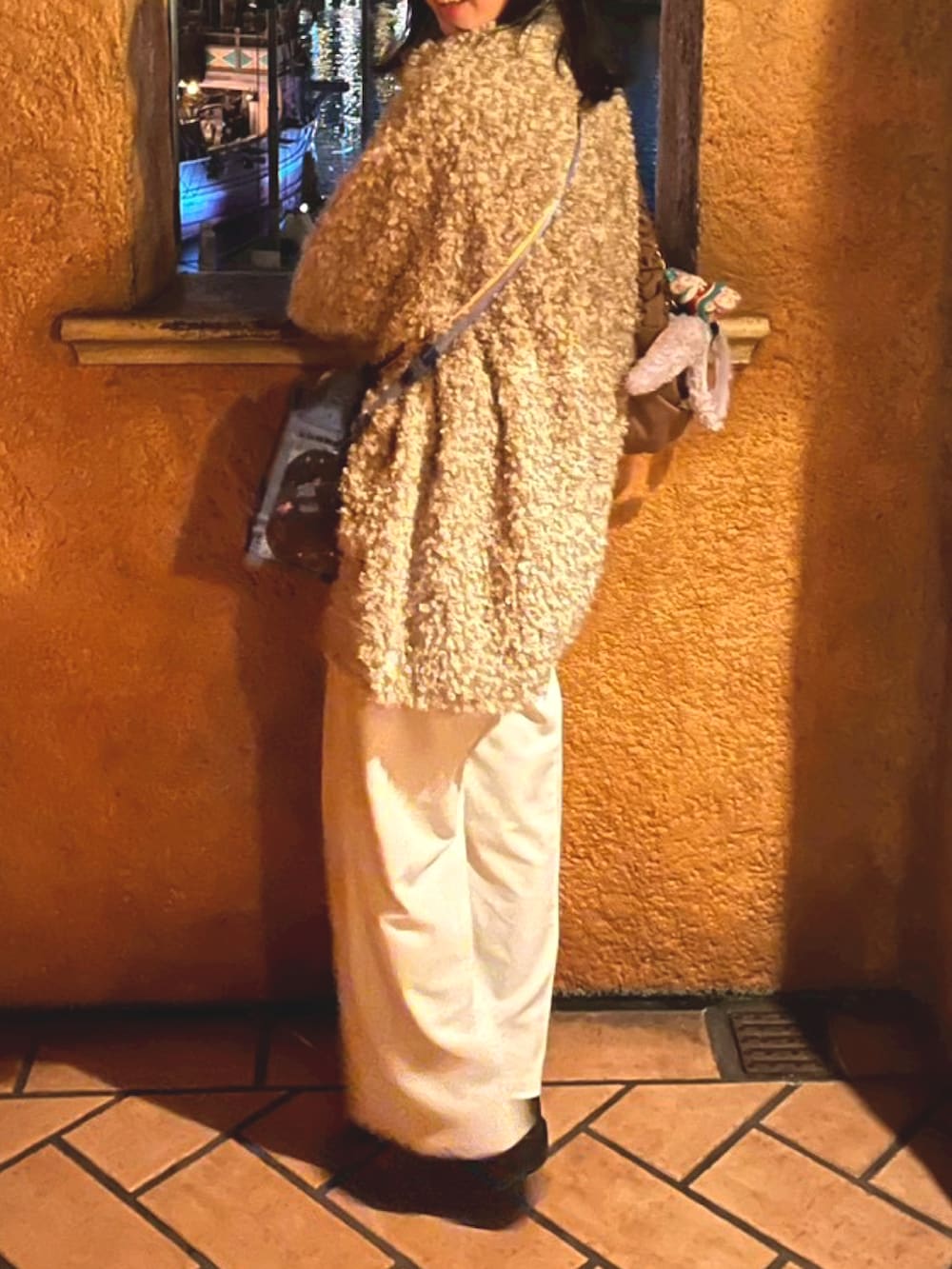 ホワイト系のブルゾン、ホワイト系のスラックスを着用したレディースの冬コーディネートの2枚目の写真