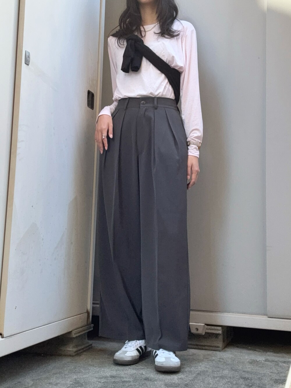 グレー系のスラックス、ピンク系のTシャツ/カットソー、ブラック系のカーディガン/ボレロを着用したレディースの秋コーディネートの2枚目の写真