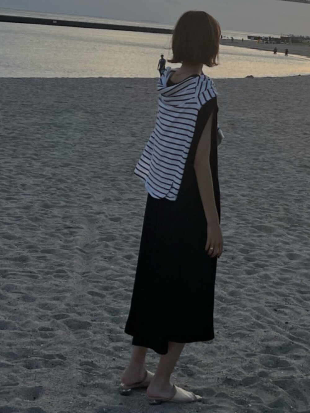 ブラック系のワンピース、ブラック系のニット/セーター、ベージュ系のサンダルを着用したレディースの夏コーディネートの2枚目の写真