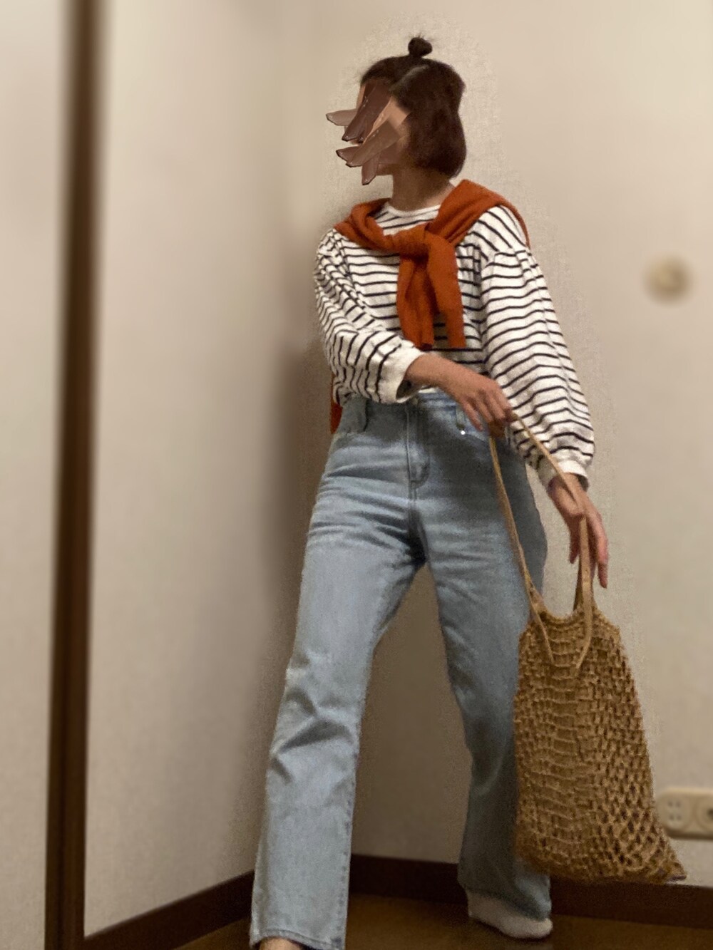 ブルー系のデニムパンツ、イエロー系のトートバッグ、ブラック系のニット/セーターを着用したレディースの夏コーディネートの2枚目の写真