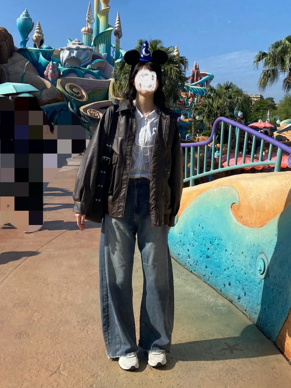 ブラウン系のブルゾン、ブラック系のショルダーバッグ、ブルー系のデニムパンツを着用したレディースの秋コーディネートの2枚目の写真