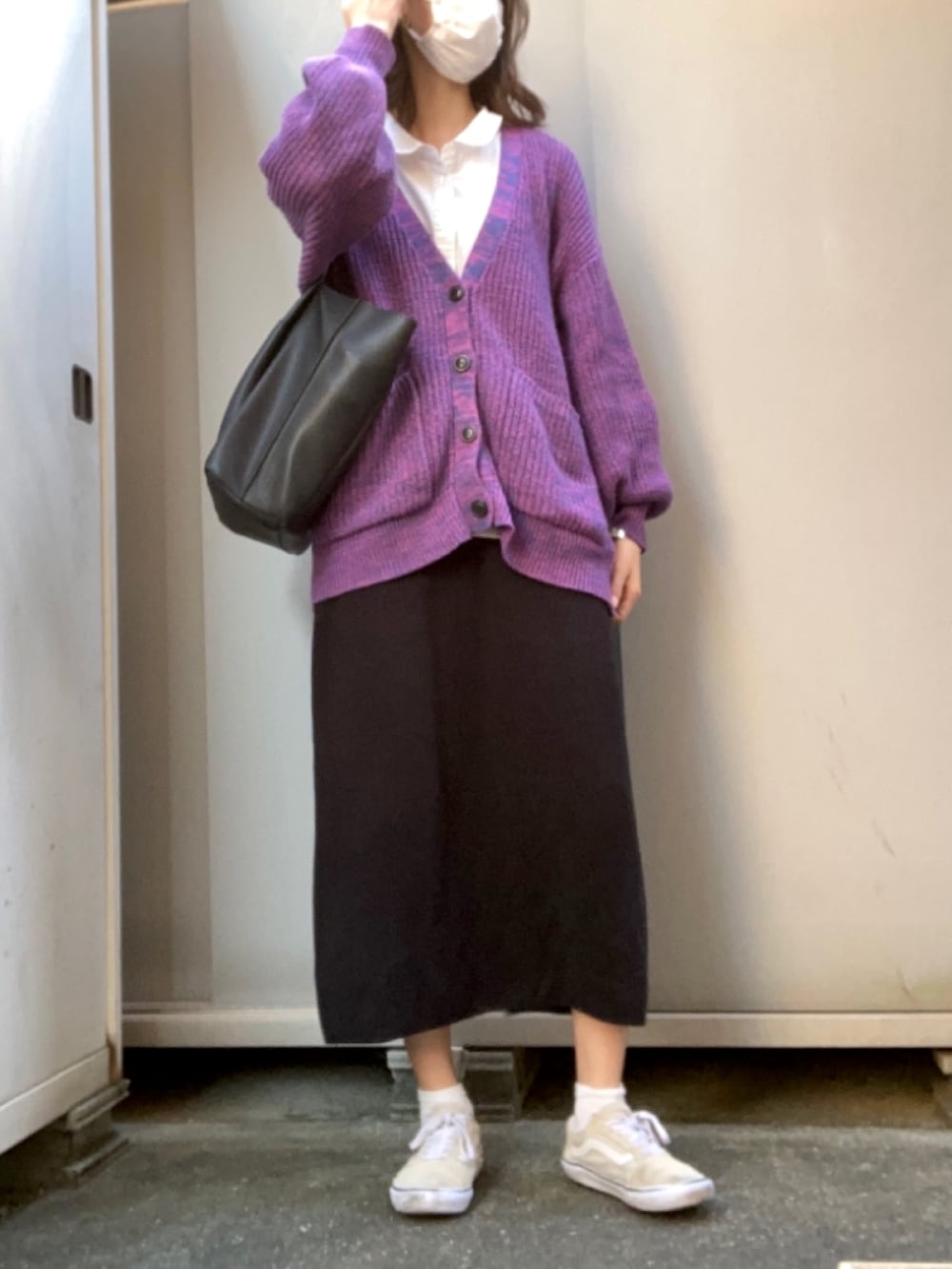 ピンク系のカーディガン/ボレロ、ブラック系のスカート、ベージュ系のスニーカーを着用したレディースの冬コーディネートの2枚目の写真