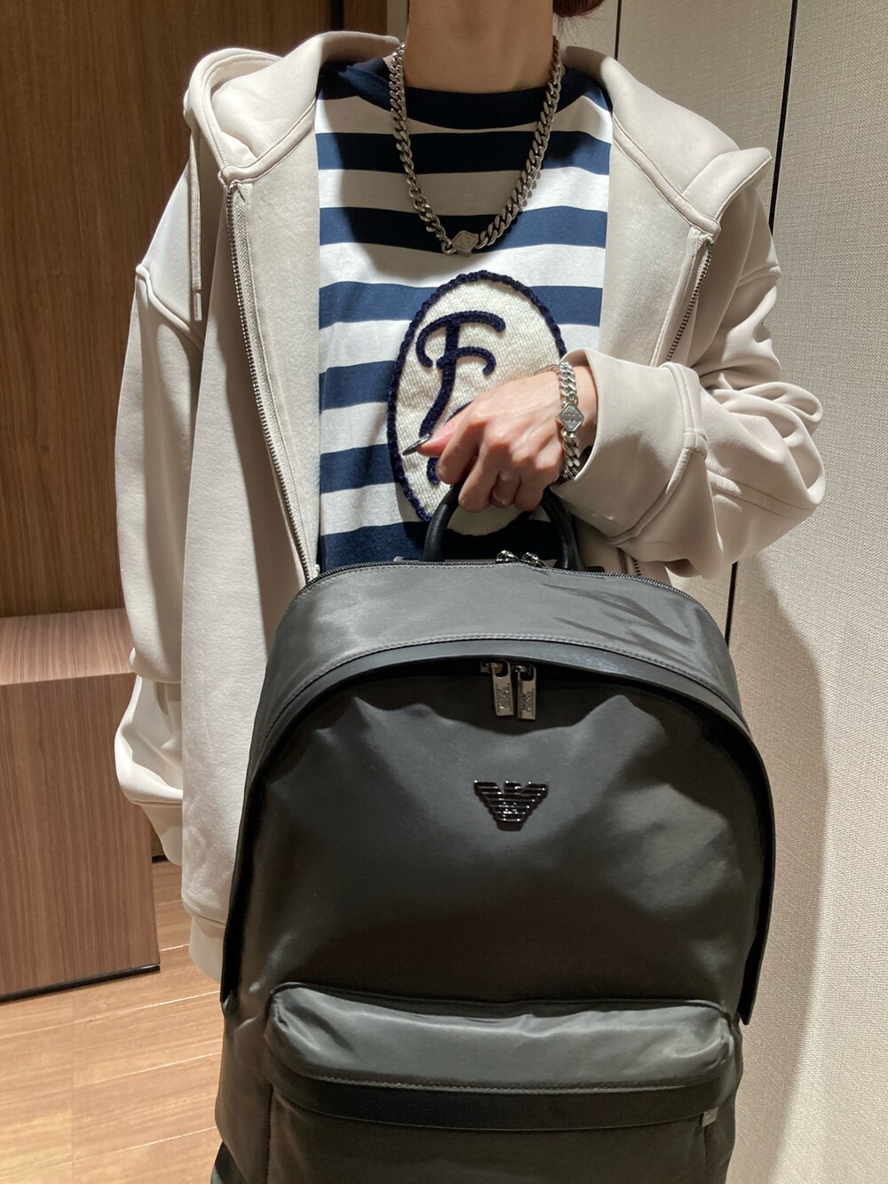 ホワイト系のTシャツ/カットソー、ベージュ系のスウェット、ブラック系のバックパック/リュックを着用したレディースの冬コーディネートの2枚目の写真