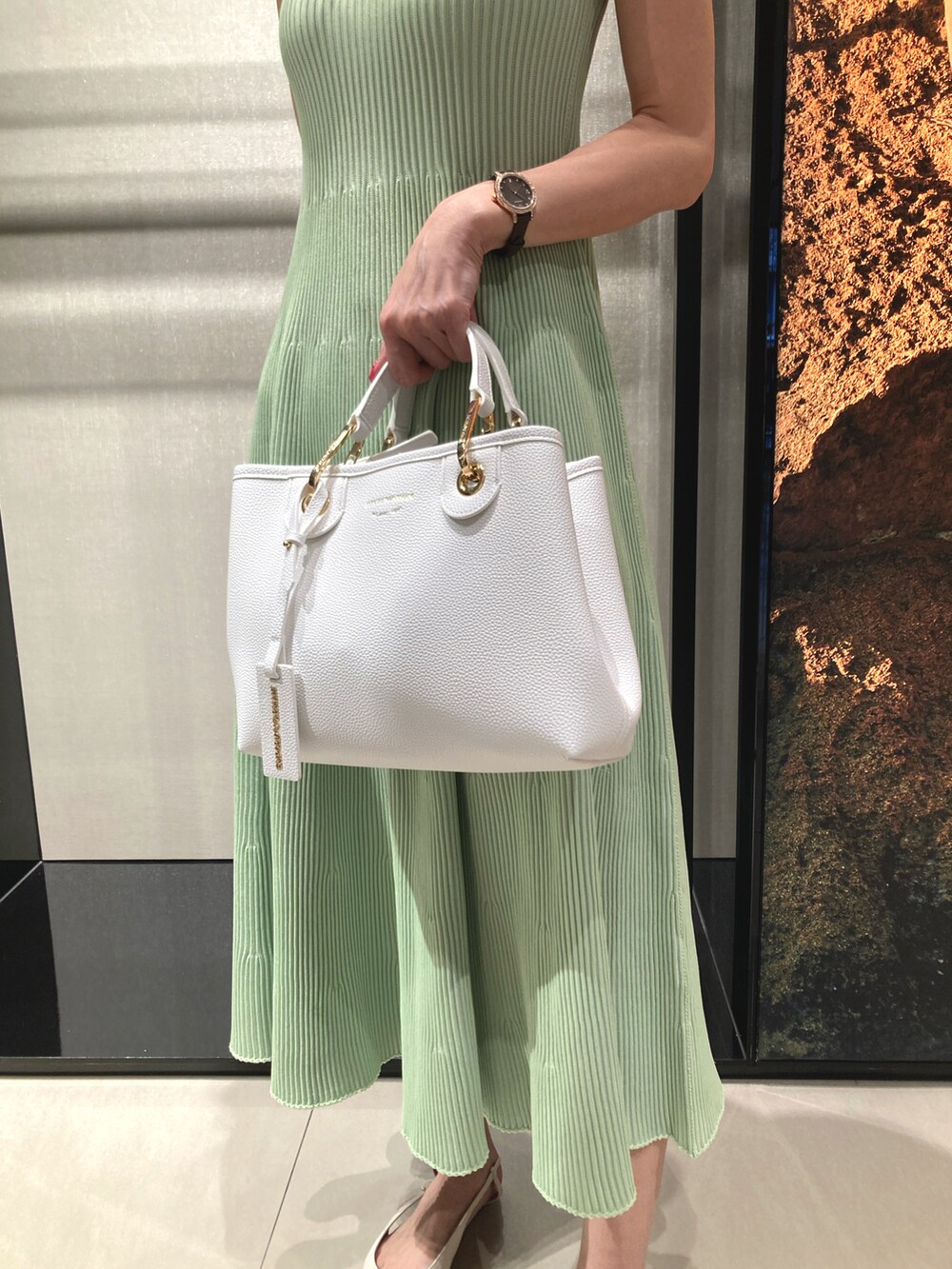 グリーン系のワンピース、ホワイト系のハンドバッグ、その他のネックレスを着用したレディースの春コーディネートの2枚目の写真