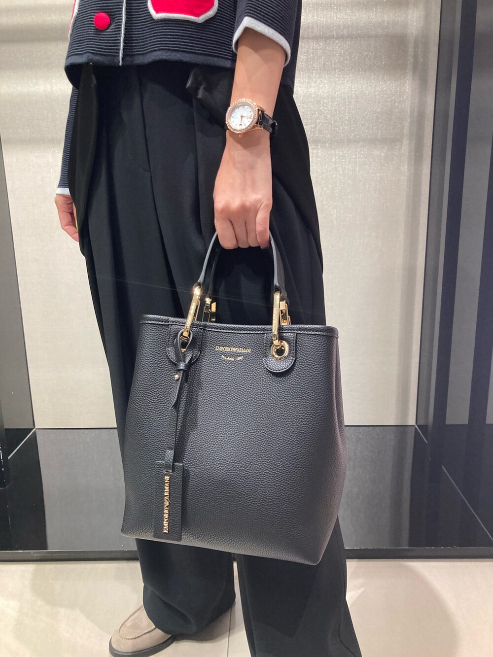 ブルー系のジャケット/アウター、ブラック系のハンドバッグ、ブラック系のパンツを着用したレディースの夏コーディネートの2枚目の写真