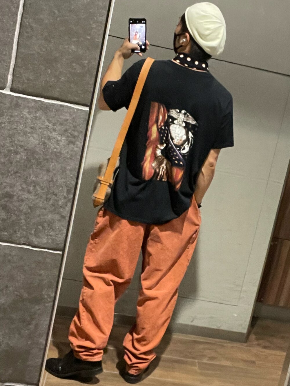 ブラウン系のショルダーバッグ、オレンジ系のその他パンツ、ブラック系のドレスシューズを着用したメンズの秋コーディネートの2枚目の写真