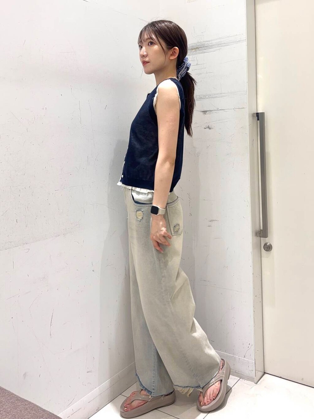 ベージュ系のサンダル、ブルー系のニット/セーター、ブルー系のデニムパンツを着用したレディースの夏コーディネートの2枚目の写真