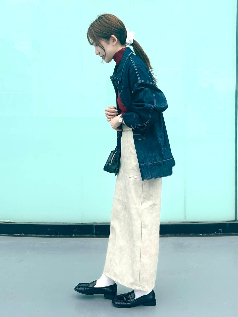 レッド系のニット/セーター、ブラック系のローファー、ホワイト系のスカートを着用したレディースの秋コーディネートの3枚目の写真