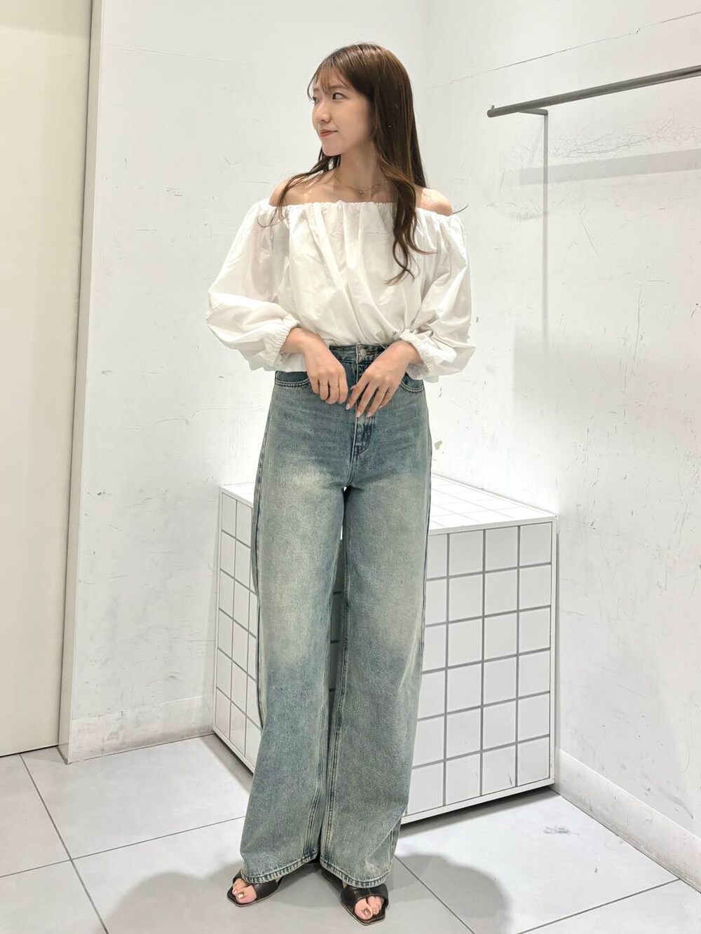 グレー系のサンダル、ホワイト系のシャツ/ブラウス、ブルー系のデニムパンツを着用したレディースの夏コーディネートの6枚目の写真