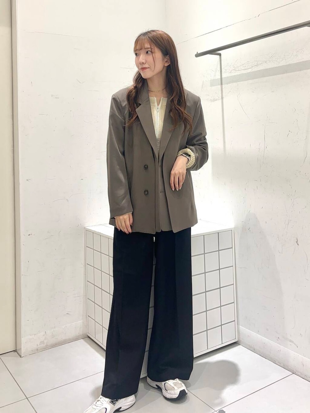 ブラック系のその他パンツ、ホワイト系のニット/セーター、ブラウン系のテーラードジャケットを着用したレディースの秋コーディネートの2枚目の写真