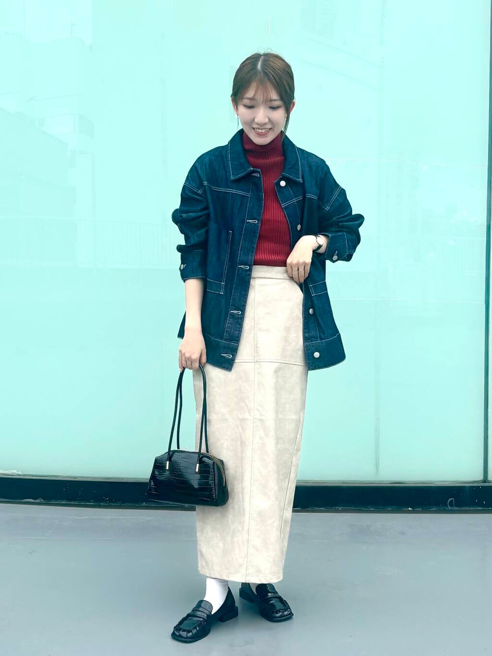 レッド系のニット/セーター、ブラック系のローファー、ホワイト系のスカートを着用したレディースの秋コーディネートの2枚目の写真