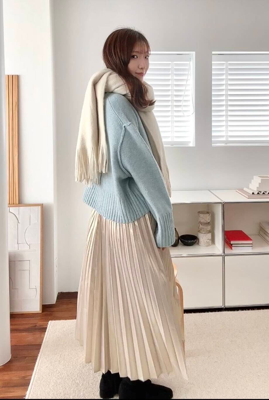 ブラック系のブーツ、ゴールド系のスカート、ブルー系のニット/セーターを着用したレディースの冬コーディネートの3枚目の写真