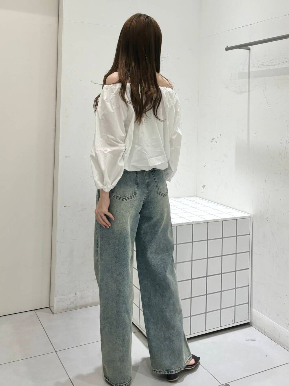 グレー系のサンダル、ホワイト系のシャツ/ブラウス、ブルー系のデニムパンツを着用したレディースの夏コーディネートの5枚目の写真