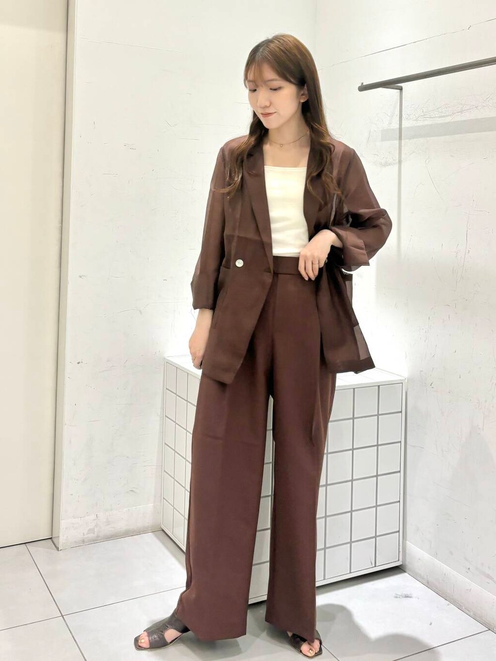 グレー系のサンダル、ホワイト系のキャミソール、ブラウン系のテーラードジャケットを着用したレディースの夏コーディネートの2枚目の写真