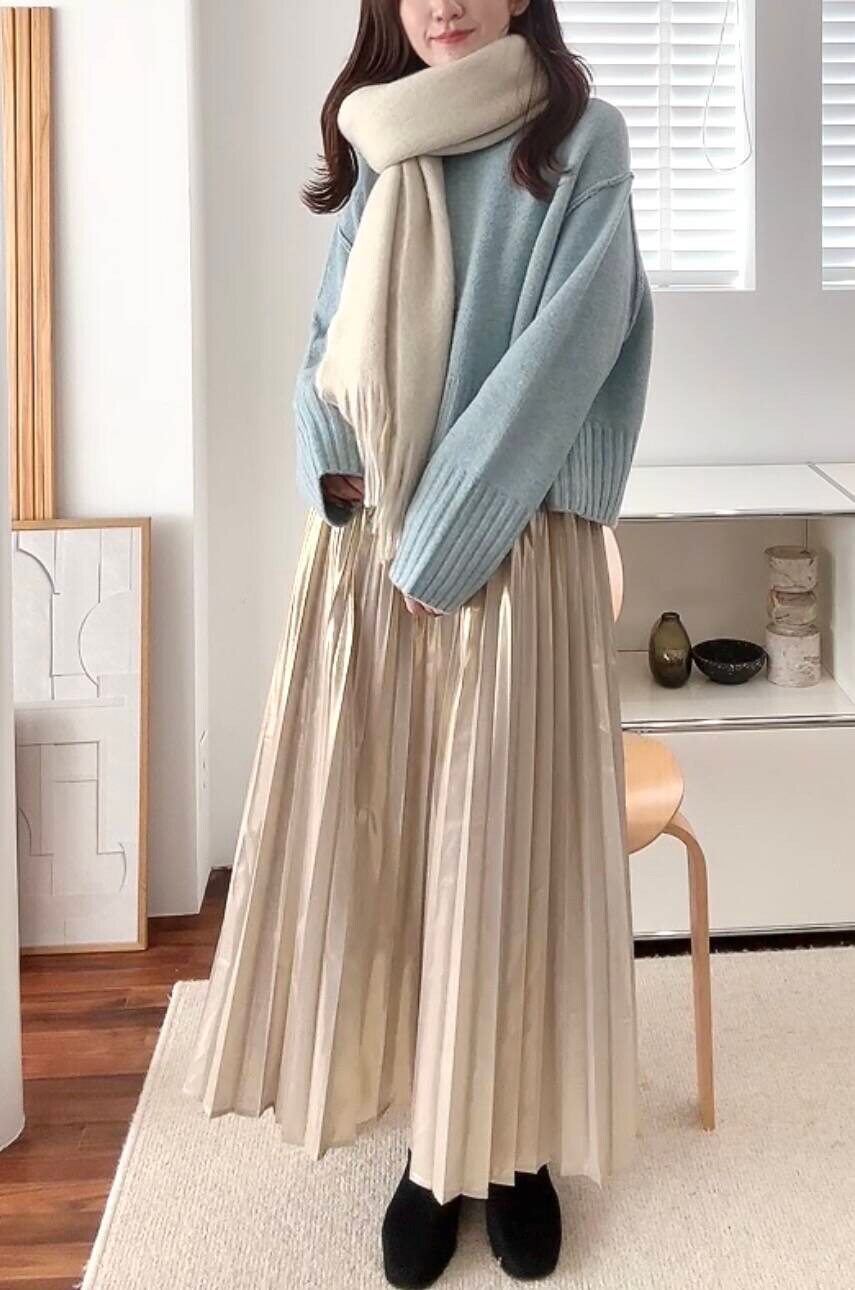 ブラック系のブーツ、ゴールド系のスカート、ブルー系のニット/セーターを着用したレディースの冬コーディネートの4枚目の写真