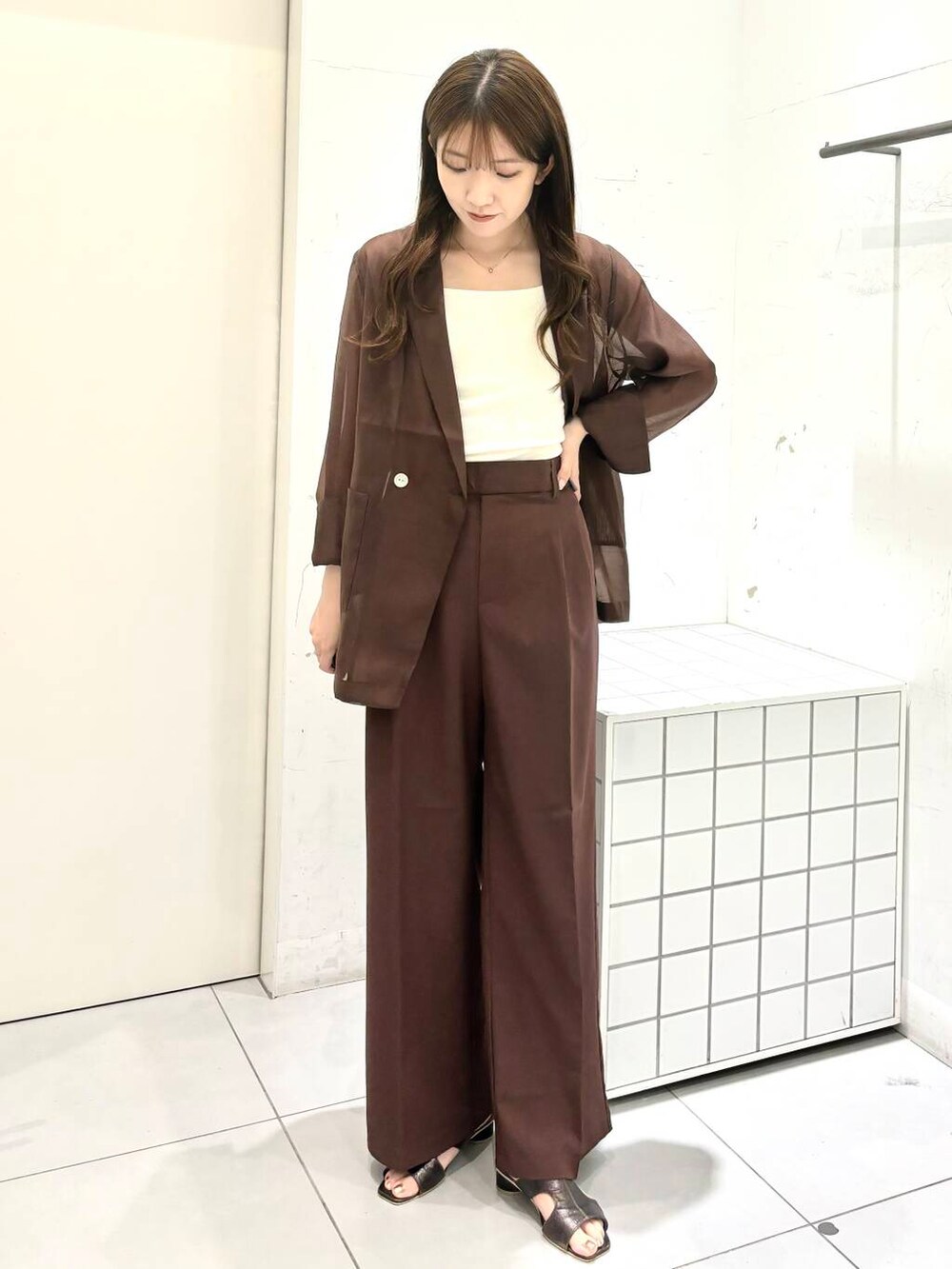 グレー系のサンダル、ホワイト系のキャミソール、ブラウン系のテーラードジャケットを着用したレディースの夏コーディネートの5枚目の写真