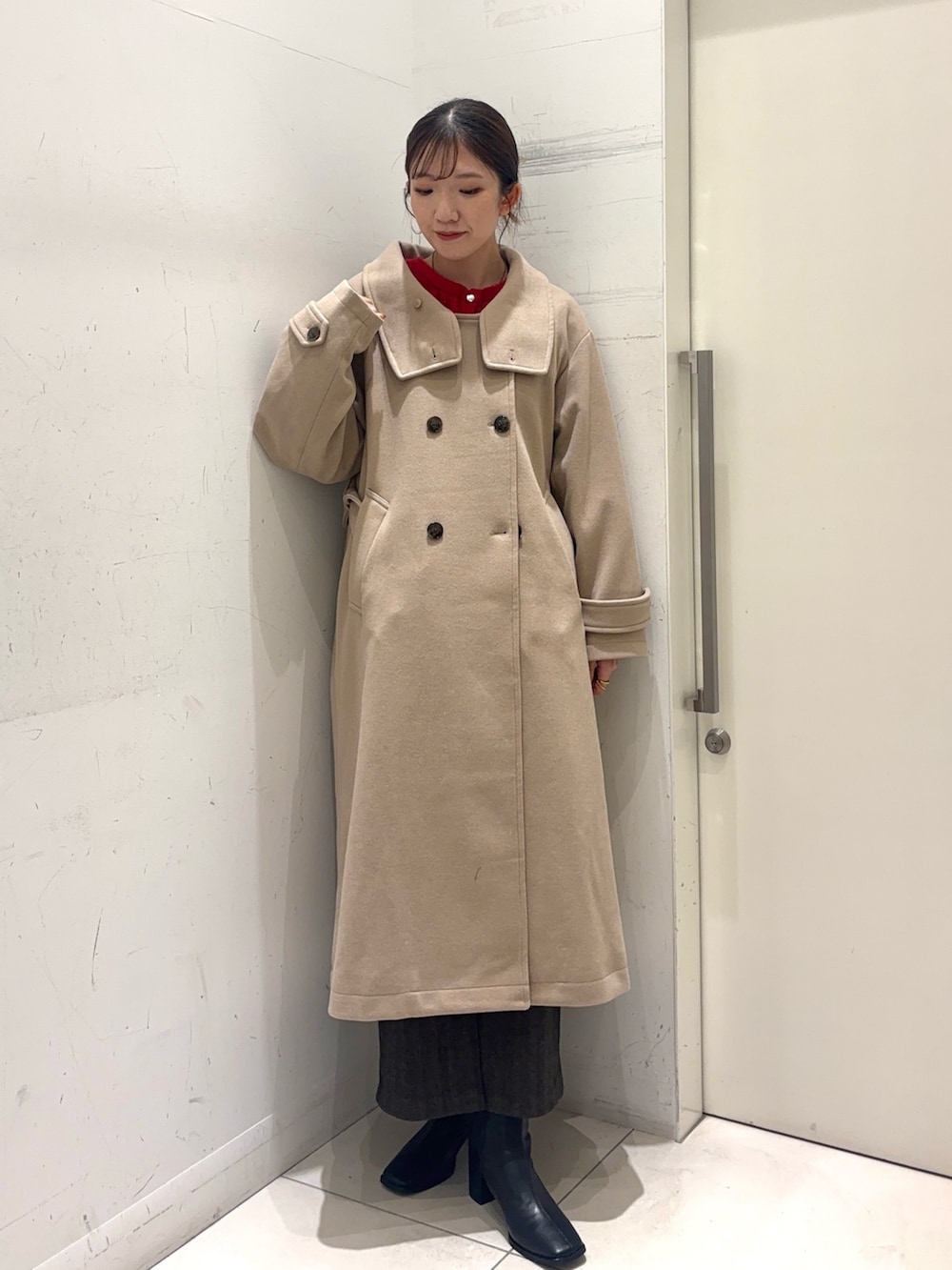 レッド系のカーディガン/ボレロ、ベージュ系のステンカラーコート、ブラウン系のスカートを着用したレディースの秋コーディネートの5枚目の写真