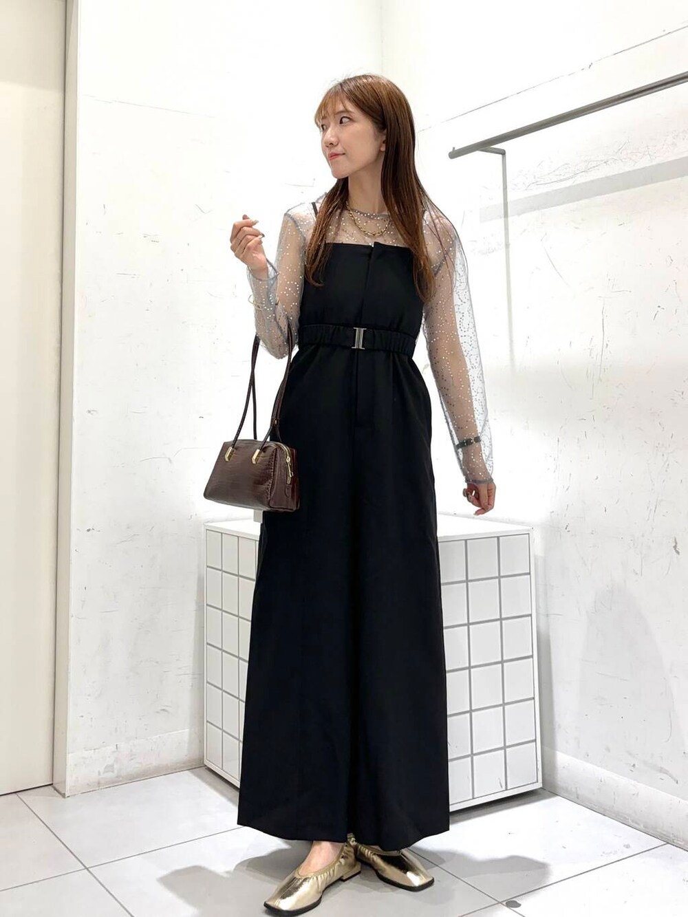 ブラック系のサロペット/オーバーオール、シルバー系のTシャツ/カットソー、ゴールド系のバレエシューズを着用したレディースの秋コーディネートの2枚目の写真