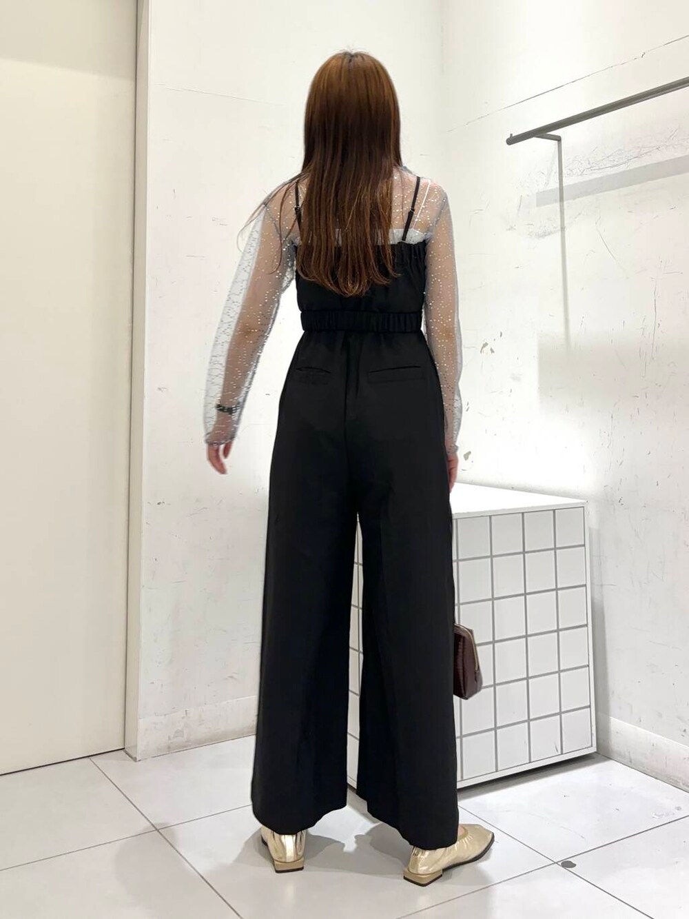 ブラック系のサロペット/オーバーオール、シルバー系のTシャツ/カットソー、ゴールド系のバレエシューズを着用したレディースの秋コーディネートの4枚目の写真