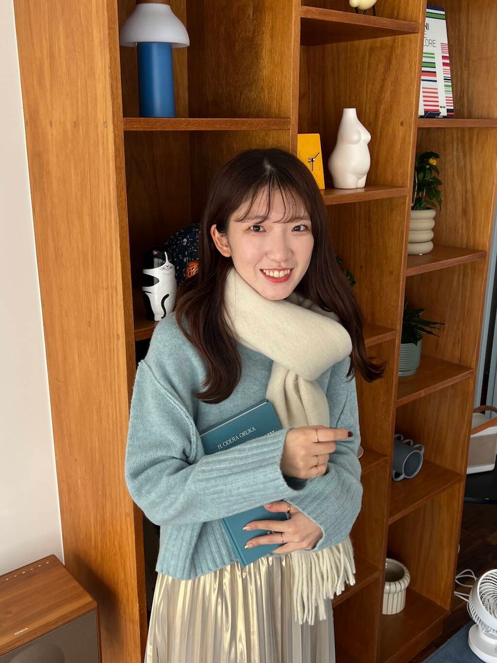 ブラック系のブーツ、ゴールド系のスカート、ブルー系のニット/セーターを着用したレディースの冬コーディネートの2枚目の写真