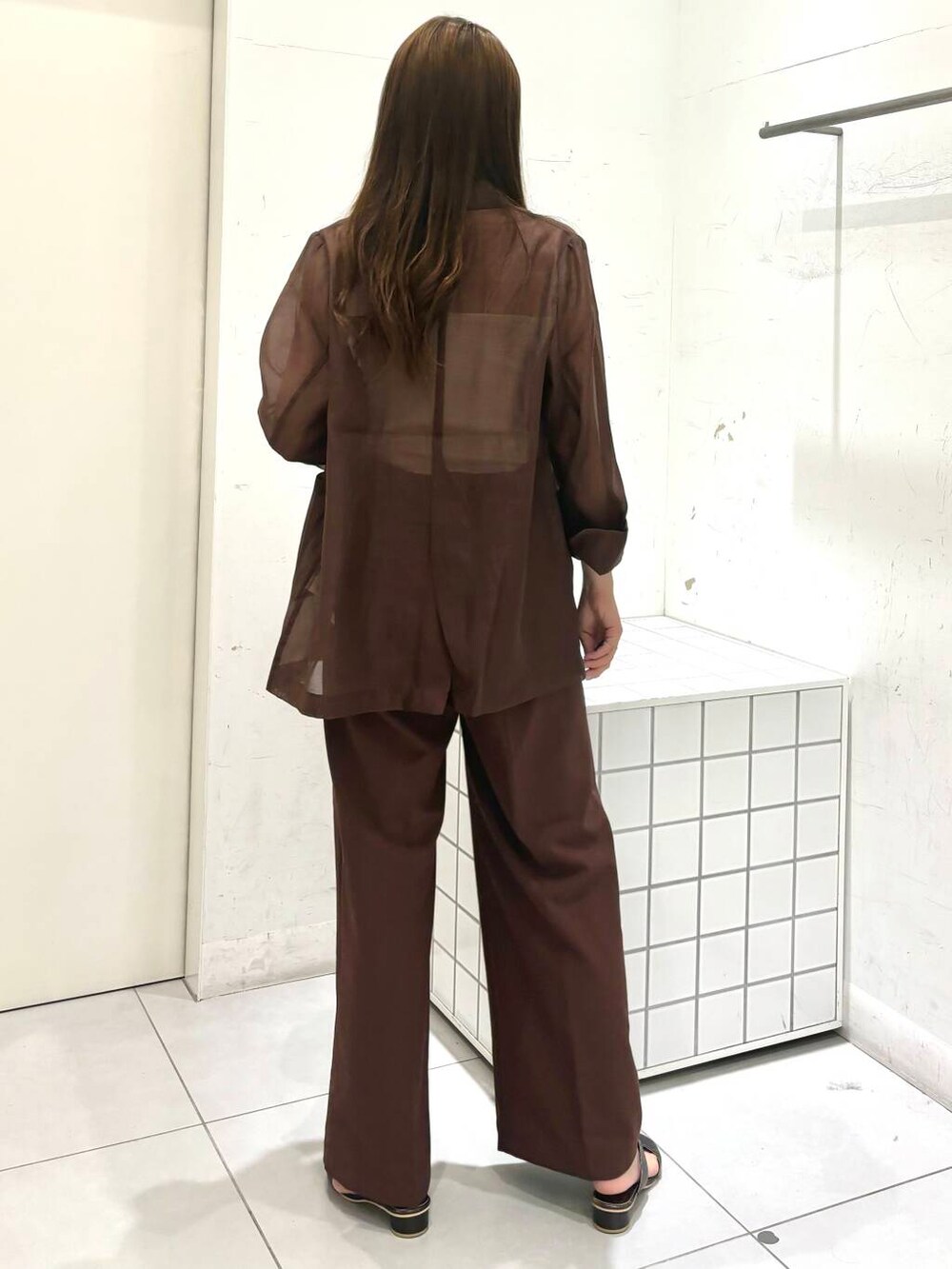 グレー系のサンダル、ホワイト系のキャミソール、ブラウン系のテーラードジャケットを着用したレディースの夏コーディネートの4枚目の写真