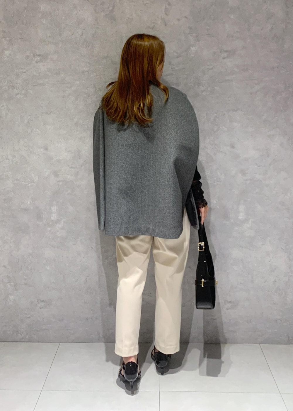 ブラック系のパンプス、グレー系のポンチョ、ブラック系のTシャツ/カットソーを着用したレディースの秋コーディネートの5枚目の写真