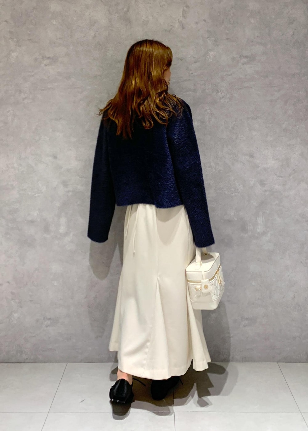 ブルー系のカーディガン/ボレロ、ホワイト系のハンドバッグ、ブラック系のパンプスを着用したレディースの秋コーディネートの5枚目の写真
