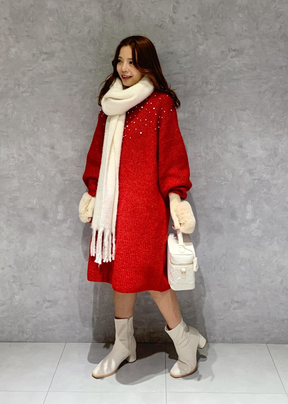 ホワイト系のブーツ、ホワイト系のハンドバッグ、レッド系のワンピースを着用したレディースの冬コーディネートの3枚目の写真