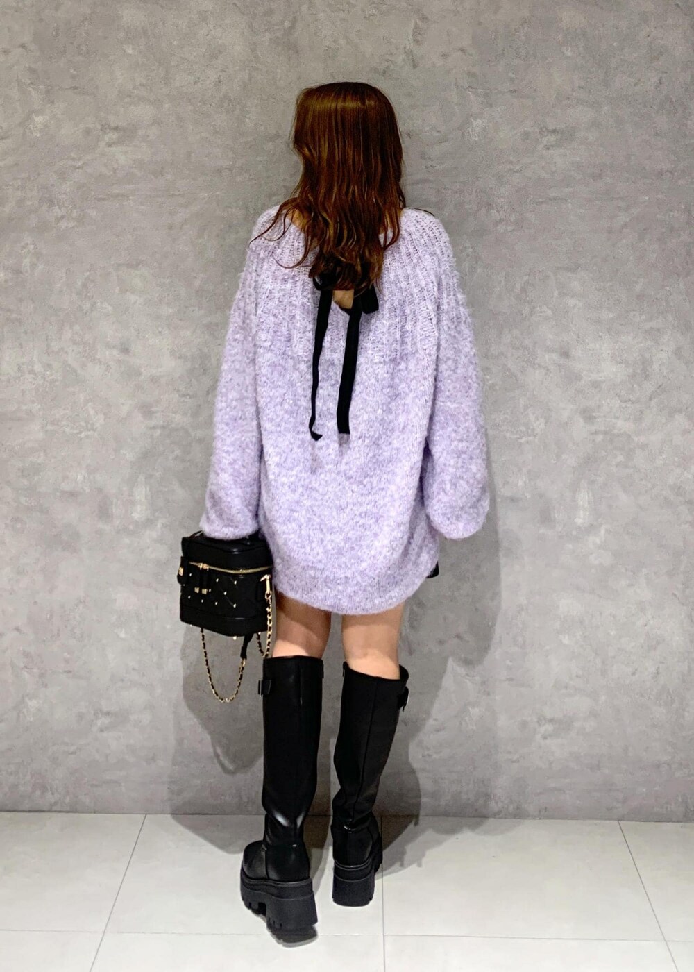 ブラック系のブーツ、パープル系のニット/セーター、ブラック系のその他パンツを着用したレディースの冬コーディネートの6枚目の写真