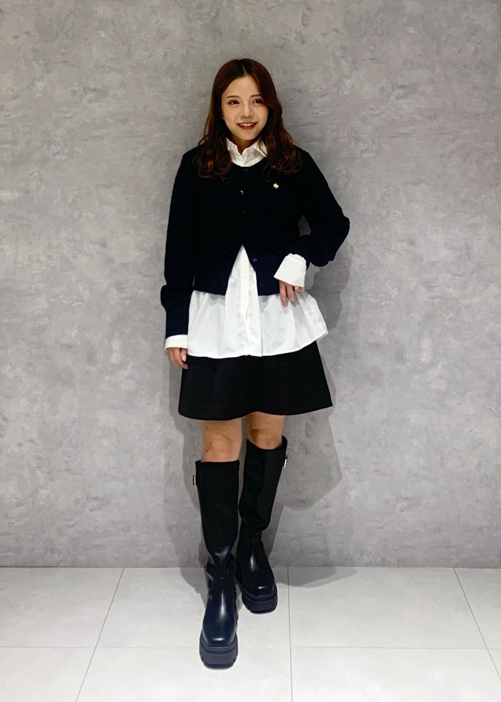 ブラック系のブーツ、ブラック系のスカート、ブルー系のその他アウターを着用したレディースの秋コーディネートの5枚目の写真